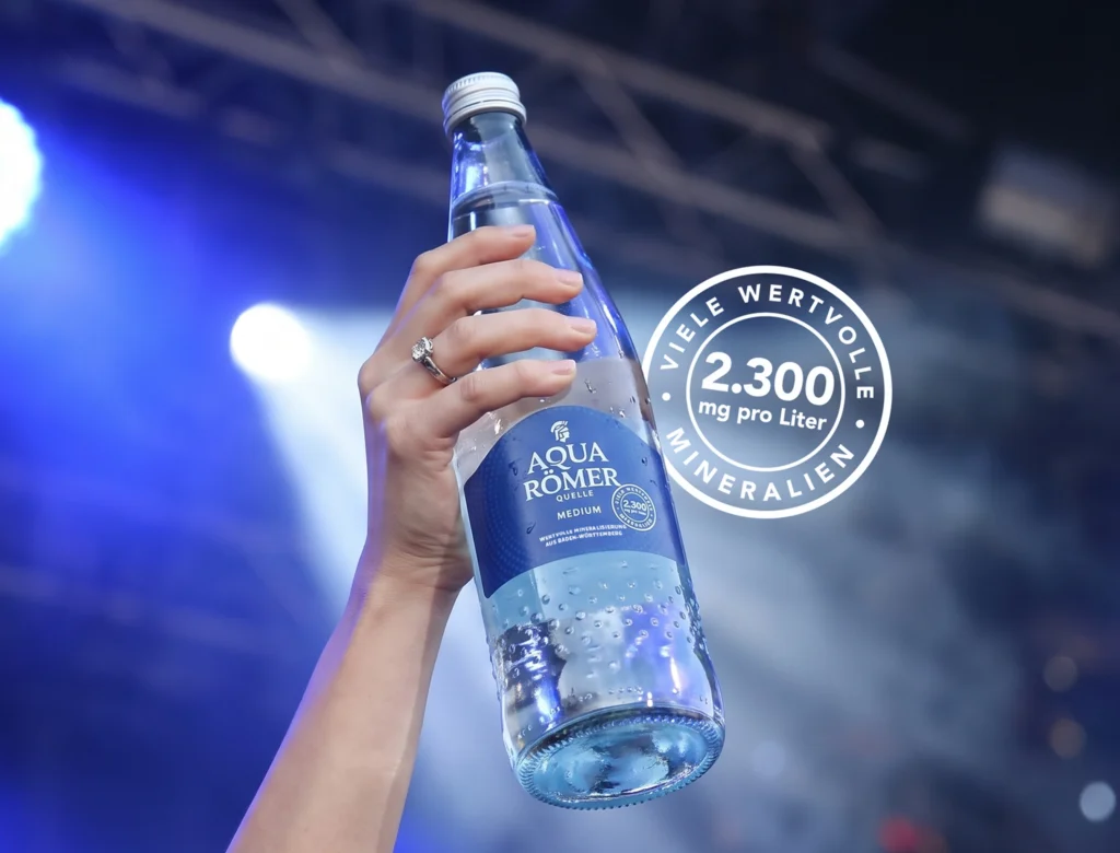 Mineralwasserflasche die von einer Hand hochgehalten wird.